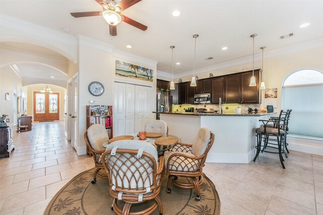 dining space with arched walkways, visible vents, and recessed lighting