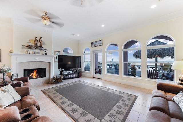 2662 E Bayshore Dr, Dickinson, TX 77539 - tiled living room featuring ornamental molding, a tiled fireplace, a ceiling fan, and recessed lighting