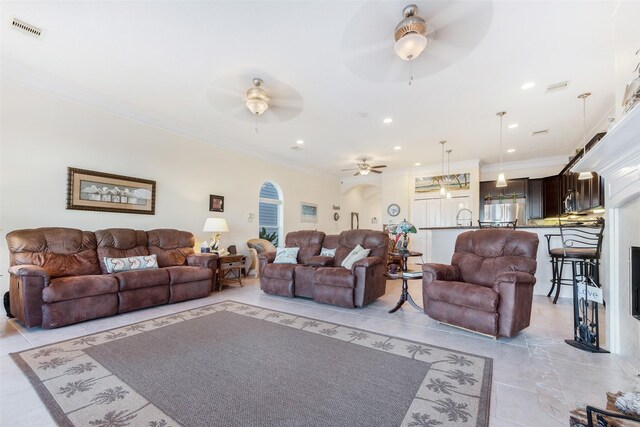 living area featuring a ceiling fan, recessed lighting, ornamental molding, and visible vents