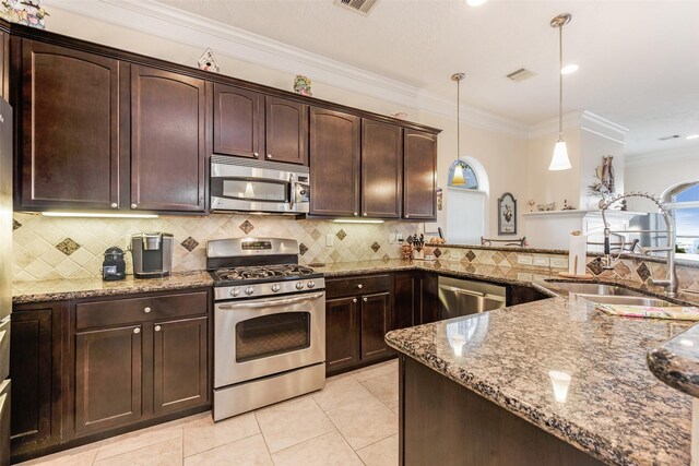 kitchen featuring a sink, stone countertops, dark brown cabinetry, backsplash, and appliances with stainless steel finishes