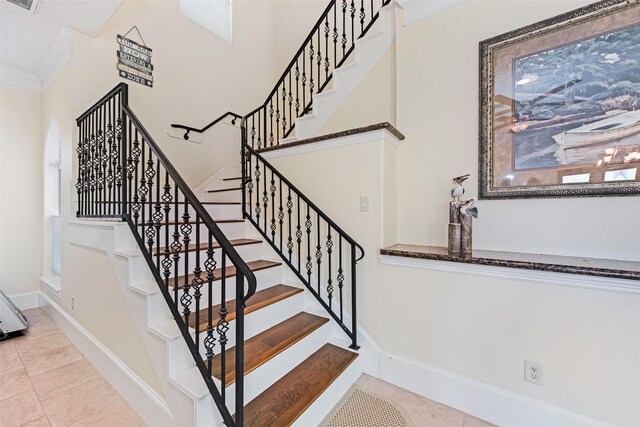 stairs with tile patterned flooring, ornamental molding, baseboards, and visible vents
