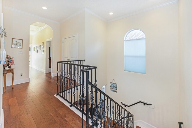 hall with wood finished floors, an upstairs landing, recessed lighting, arched walkways, and baseboards