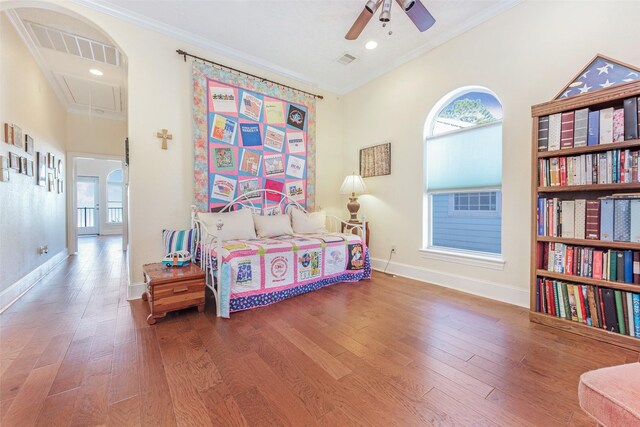 bedroom featuring attic access, baseboards, visible vents, crown molding, and wood finished floors