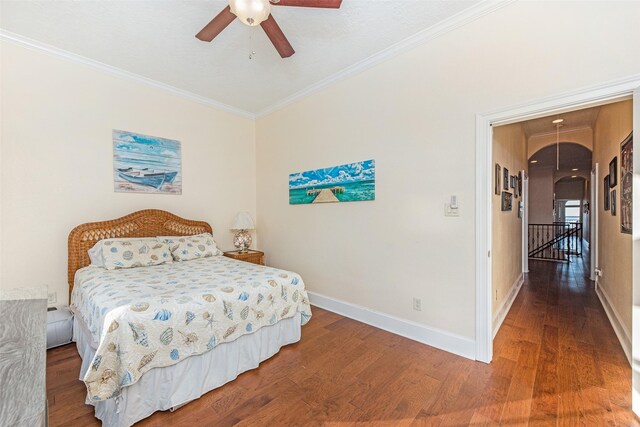 bedroom with crown molding, baseboards, a ceiling fan, and wood finished floors