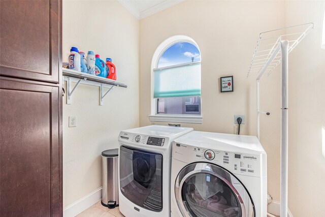 laundry room featuring independent washer and dryer, baseboards, light tile patterned flooring, crown molding, and cabinet space