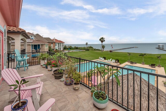 balcony featuring a water view and view of pool area