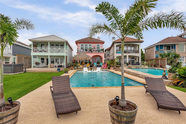 swimming pool featuring a patio area, a hot tub, and a yard