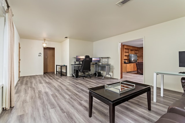 living area featuring baseboards, visible vents, and light wood-style floors