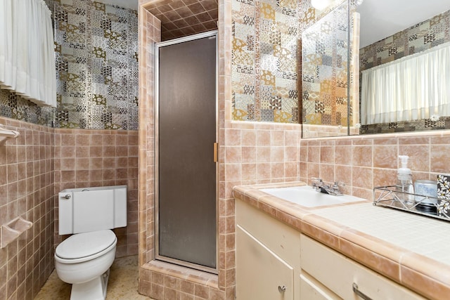 full bathroom featuring a stall shower, vanity, tile walls, and toilet