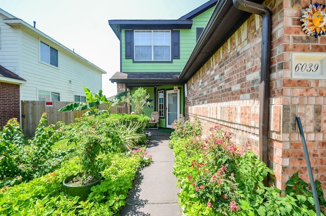 entrance to property with fence and brick siding