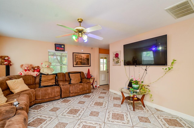 living area featuring ceiling fan, light tile patterned floors, and baseboards