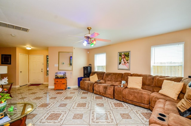 living area featuring light tile patterned flooring, baseboards, and a ceiling fan