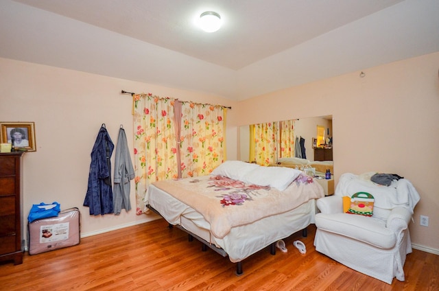 bedroom with wood finished floors and baseboards