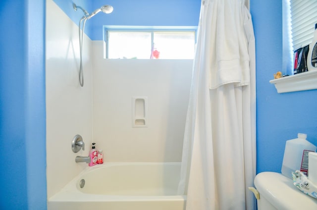 bathroom featuring shower / bath combination with curtain and toilet