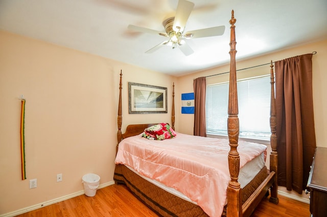 bedroom with wood finished floors, a ceiling fan, and baseboards