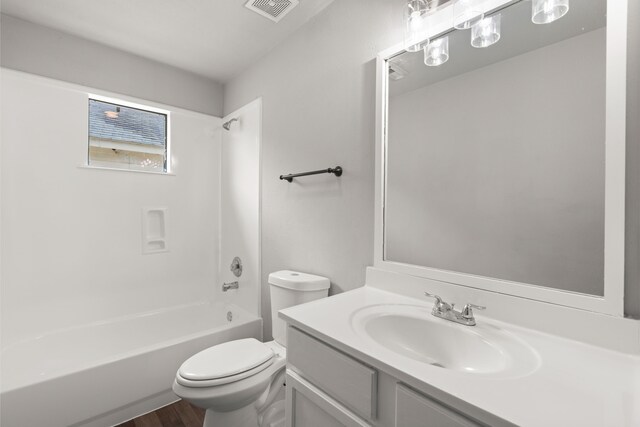 bathroom with toilet, wood finished floors, washtub / shower combination, visible vents, and vanity