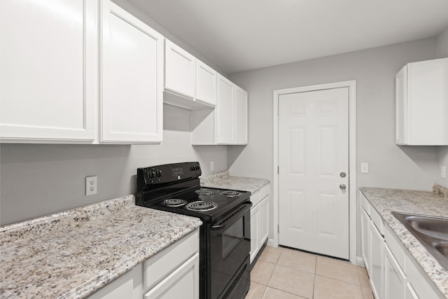 kitchen featuring light tile patterned floors, black range with electric stovetop, a sink, and white cabinets