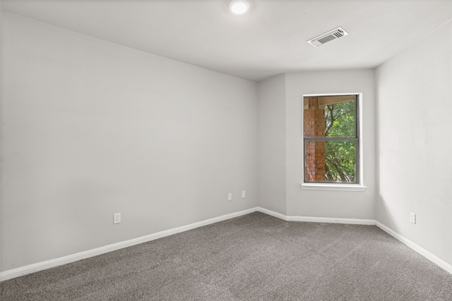 empty room with carpet, baseboards, and visible vents