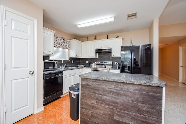 kitchen featuring black appliances, under cabinet range hood, light tile patterned floors, and backsplash