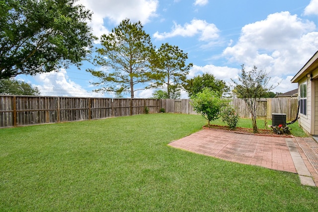 view of yard with central AC unit and a patio area