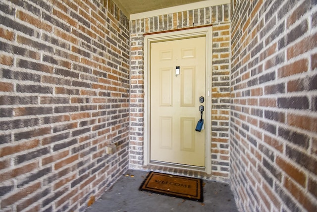 property entrance with brick siding and covered porch