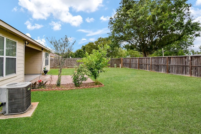 view of yard with central AC and a patio