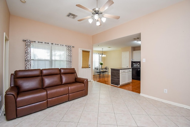 living room with ceiling fan, light tile patterned floors, and baseboards