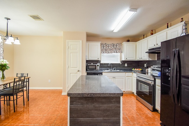 kitchen featuring stainless steel appliances, a sink, dark countertops, light tile patterned floors, and white cabinets