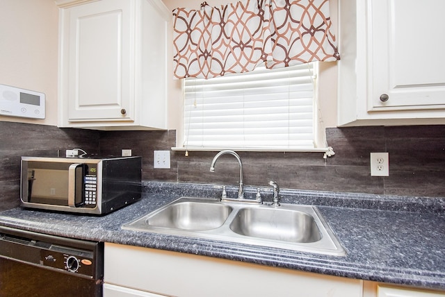 kitchen featuring black dishwasher, stainless steel microwave, a sink, and white cabinets