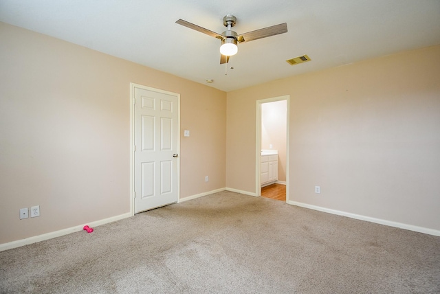 carpeted spare room with a ceiling fan and baseboards