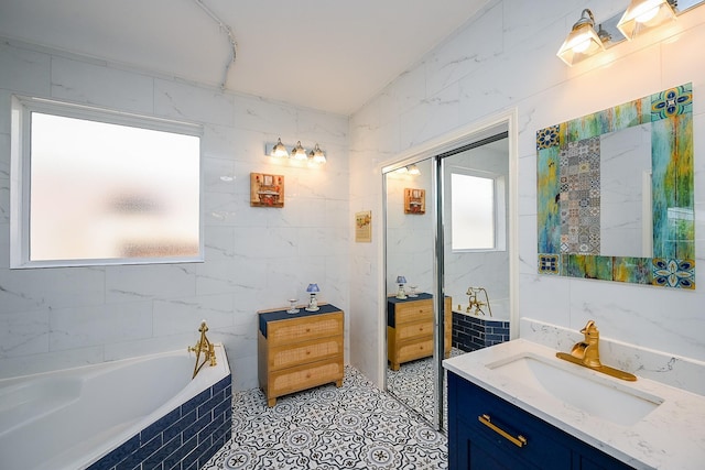 bathroom with vanity, tile walls, and a relaxing tiled tub