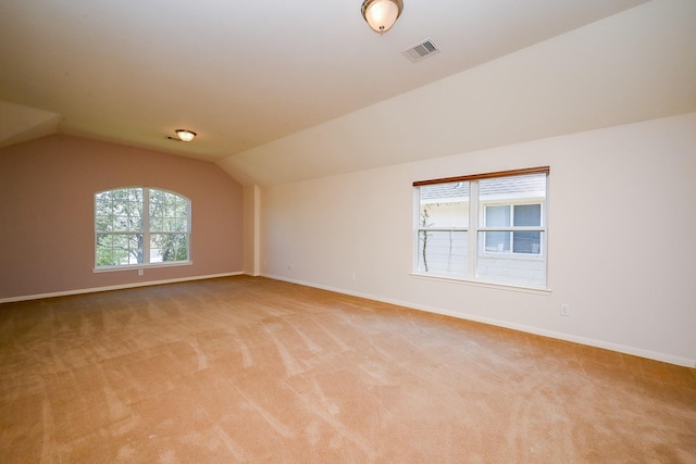 additional living space featuring light carpet, lofted ceiling, baseboards, and visible vents