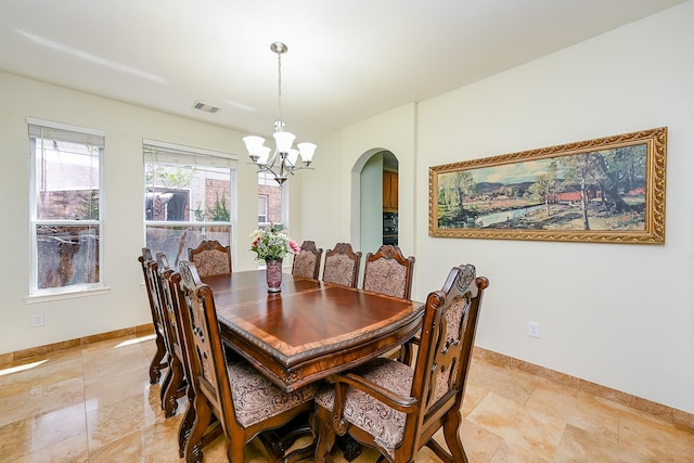 dining space featuring an inviting chandelier, arched walkways, baseboards, and visible vents