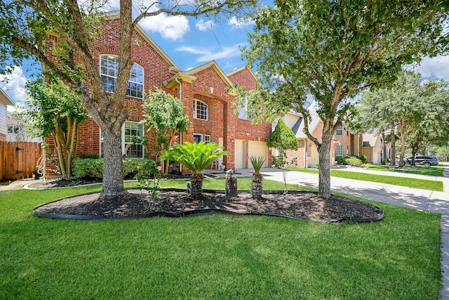 view of front facade featuring an attached garage, fence, a front yard, brick siding, and driveway