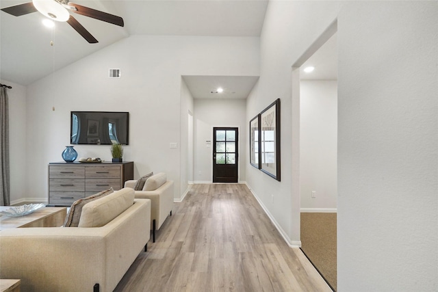 living area with light wood finished floors, high vaulted ceiling, visible vents, baseboards, and ceiling fan