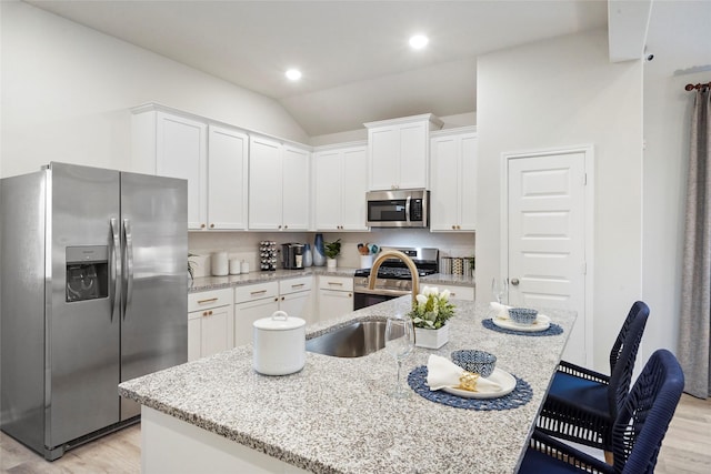 kitchen with white cabinets, appliances with stainless steel finishes, and light wood-style floors