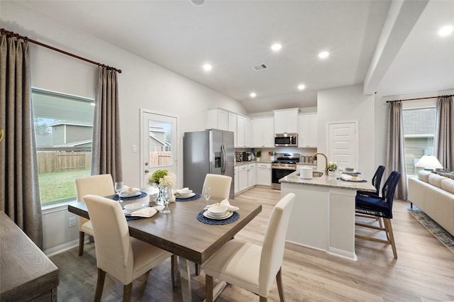 dining space with light wood-style floors, visible vents, lofted ceiling, and recessed lighting