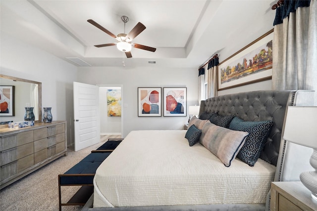 bedroom featuring light carpet, a raised ceiling, a ceiling fan, and visible vents