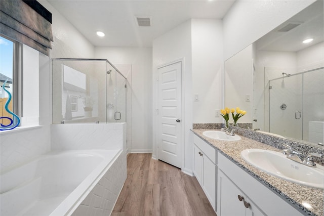bathroom with a shower stall, a bath, visible vents, and a sink