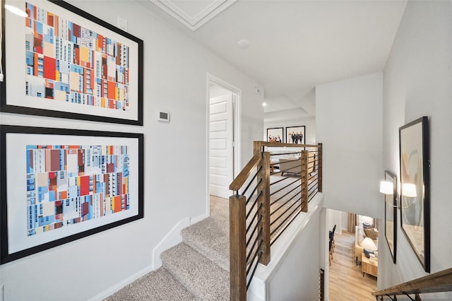 stairway featuring baseboards and carpet floors