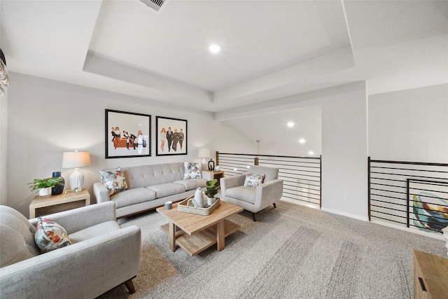 carpeted living area featuring a tray ceiling, visible vents, baseboards, and recessed lighting