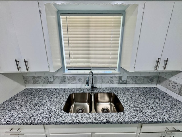 11615 Harrow St, Houston, TX 77093 - interior details featuring white cabinetry, tasteful backsplash, dark stone countertops, and a sink
