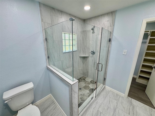 11615 Harrow St, Houston, TX 77093 - full bathroom with a walk in closet, toilet, baseboards, and a shower stall