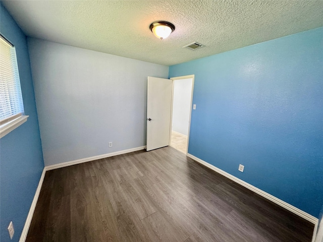 11615 Harrow St, Houston, TX 77093 - spare room featuring a textured ceiling, visible vents, wood finished floors, and baseboards