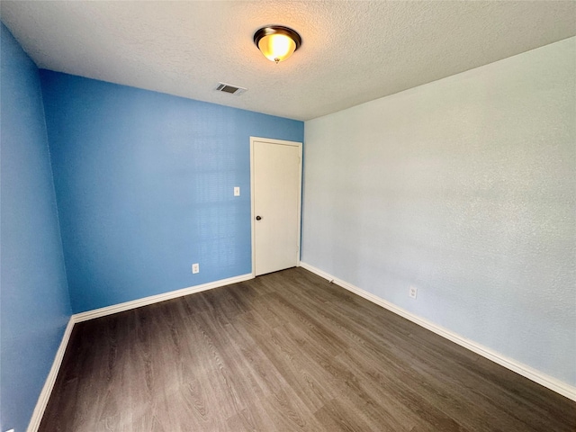 11615 Harrow St, Houston, TX 77093 - unfurnished room with baseboards, dark wood-style flooring, visible vents, and a textured ceiling