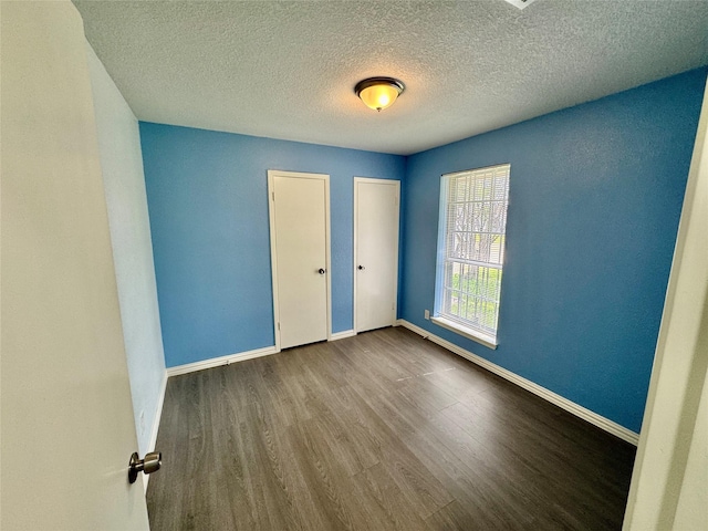11615 Harrow St, Houston, TX 77093 - unfurnished bedroom featuring a textured ceiling, wood finished floors, and baseboards