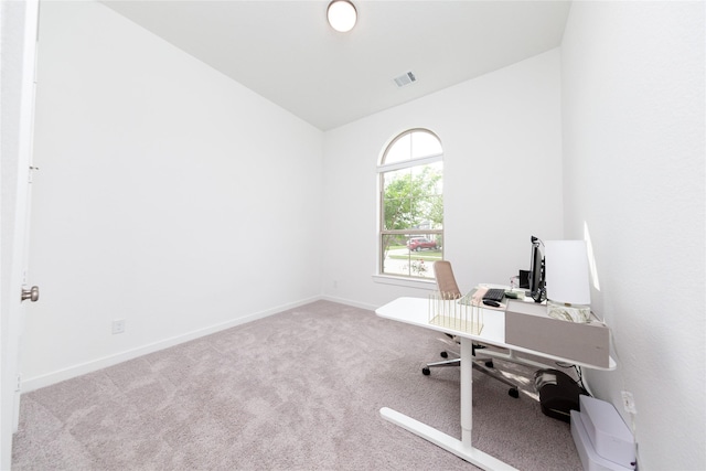 office featuring vaulted ceiling, visible vents, baseboards, and carpet floors