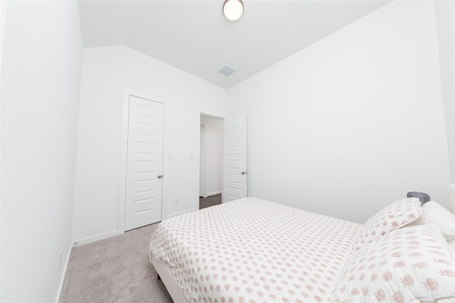 bedroom with carpet, a closet, visible vents, baseboards, and vaulted ceiling