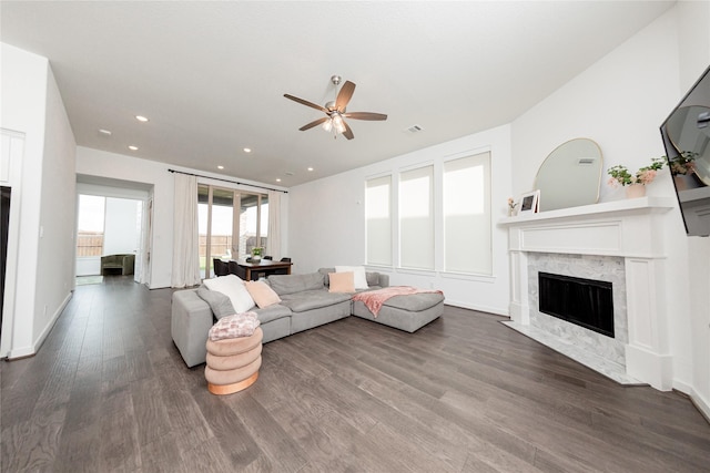 living room featuring visible vents, recessed lighting, ceiling fan, dark wood-style flooring, and a premium fireplace