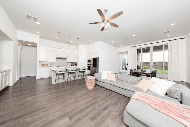 living area with ceiling fan, recessed lighting, dark wood finished floors, and visible vents